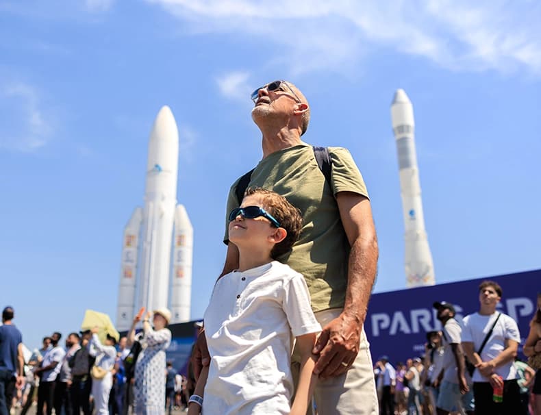 Visitors at Salon du Bourget in front of Ariane rockets